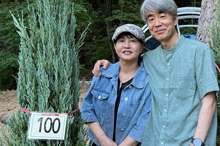 100번 생명나무 앞에서 기념 촬영하는 성도 부부